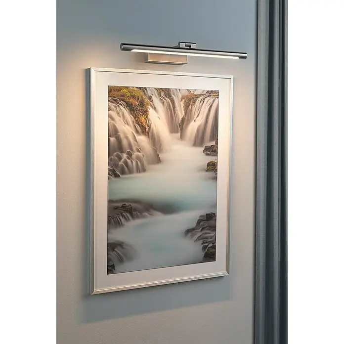 Paulmann LED-Bilderleuchte Mingo - 11 W, L x B x H: 17,5 x 41,5 x 5 cm, Alu gebürstet, Warmweiß - Wandleuchte über einem gerahmten Wasserfallbild. Das Licht betont die Details des Kunstwerks an der Wand.