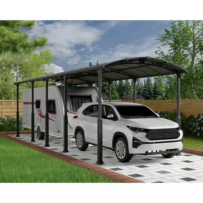 Palram – Canopia Carport Alpine - Medidas ext. (An x Pr): 3,59 x 10,77 m, Carport individual, Antracita - Una cochera con un remolque y un coche blanco debajo, que ofrece refugio y maximiza el espacio al aire libre.