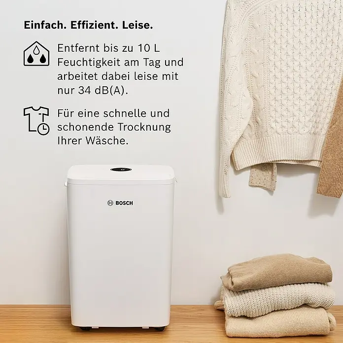 Bosch Luftentfeuchter Dry 1000 - Entfeuchtungsleistung: 10 l/Tag, Weiß - Ein weißer Bosch Luftentfeuchter steht auf einem Holzboden. Der Luftentfeuchter ist kompakt und elegant designt für den Hausgebrauch.