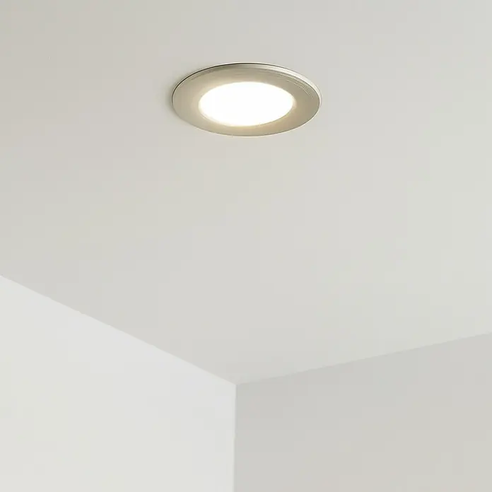 Eglo Fueva 5 Downlight empotrable LED redondo - 2,7 W, Ø x Al: 8,6 x 2,6 cm, Blanco neutro - Una moderna lámpara de techo LED en una habitación luminosa. La luz es redonda y empotrada, con un marco plateado.