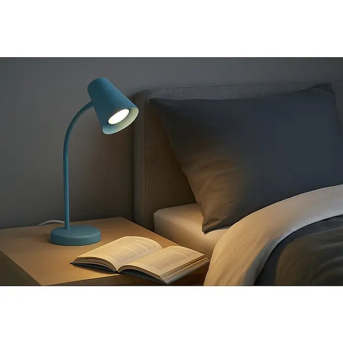 Prisma Leuchten Lámpara de sobremesa Skriva - 9 W, Azul, GU10 - Elegante lámpara de escritorio azul que ilumina un libro en una mesita de noche junto a una cama, ideal para leer por la noche.