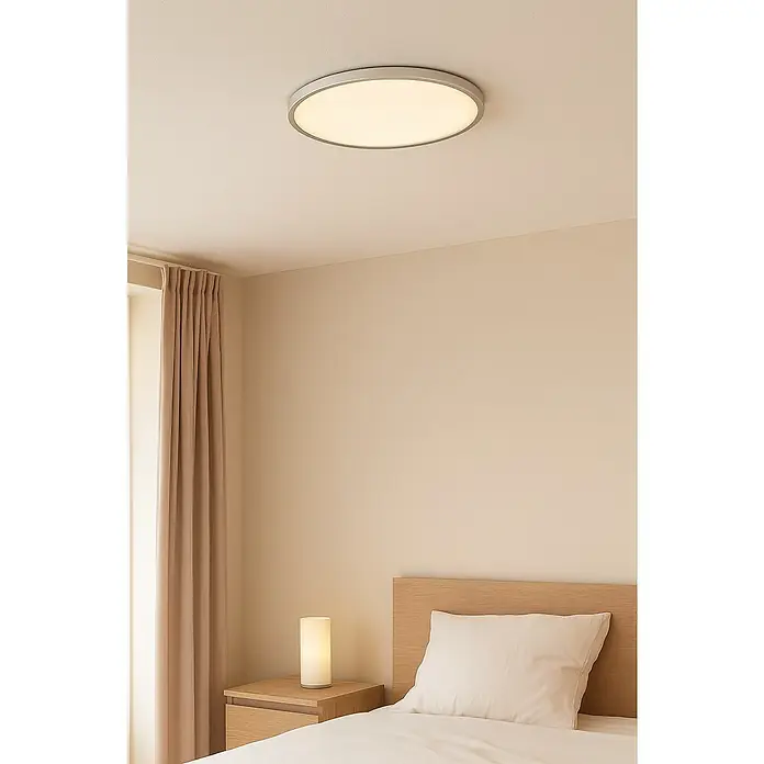 Alverlamp Foco downlight de superficie LED con mando - Blanco cálido - Primer plano de una lámpara de techo redonda y moderna con luz suave en un dormitorio, creando un ambiente cálido.
