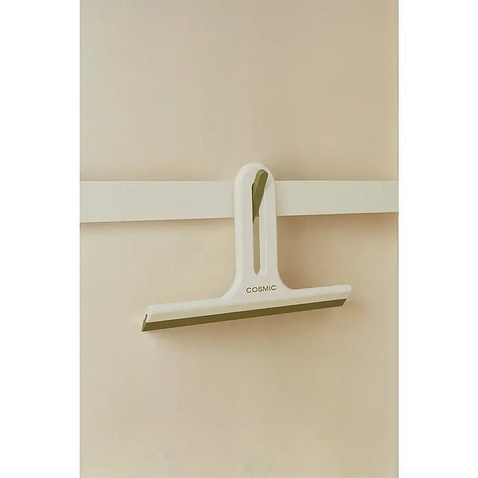 Cosmic Limpiamamparas para baño y ducha Alife - Blanco perla, Plástico (ABS) - Un escurridor de ducha COSMIC blanco y moderno cuelga de una barra blanca en una pared beige. El escurridor tiene una lámina de goma verde.