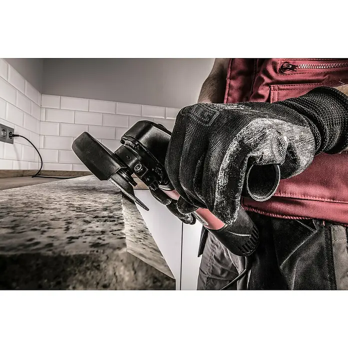 Rubi Disco de corte VDG - Ø x Es: 100 x 2,4 mm, Orificio: 22,2 mm - Un artesano con guantes protectores está trabajando en una encimera con una sierra para baldosas de mano. Herramienta para artesanos.