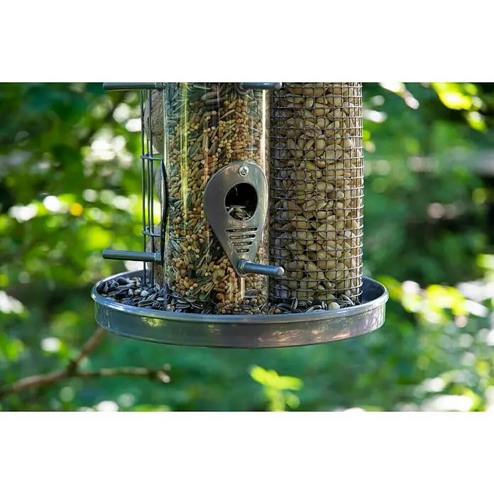 Dobar Futterspender - L x B x H: 21,5 x 21,5 x 36,5 cm, Metall, 3 Futterkammern - Nahaufnahme einer befüllten Vogeltränke mit verschiedenen Samen, die Vögel in Ihren Garten locken wird.