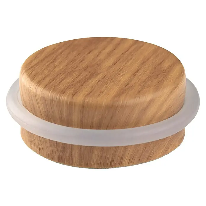 Inofix Tope de puerta 2098 - Ø x Al: 46 x 18 mm, Roble Atlántico - Primer plano de un tope de puerta redondo de madera con un anillo de goma transparente.