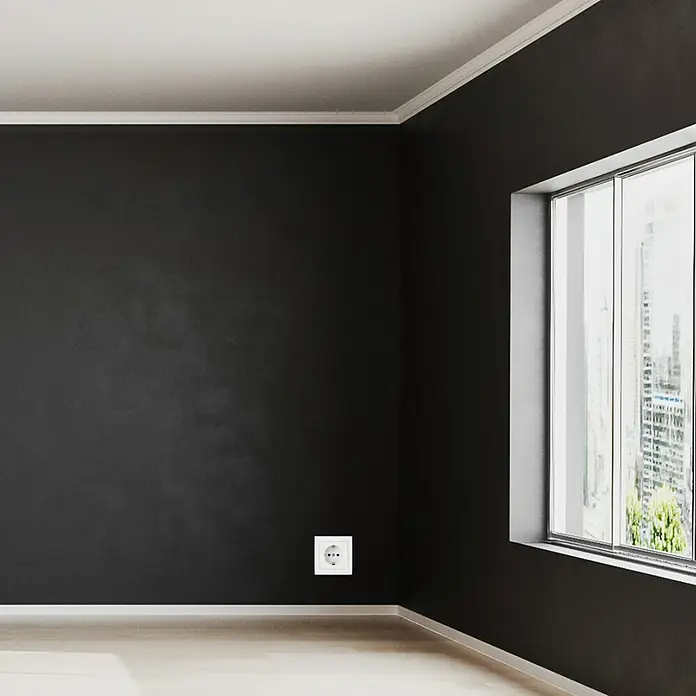Luceco Oxford Enchufe Schuko - Blanco, 16 A, 5 ud. - Un primer plano de un enchufe eléctrico en una habitación oscura, con una ventana y suelos de madera clara.