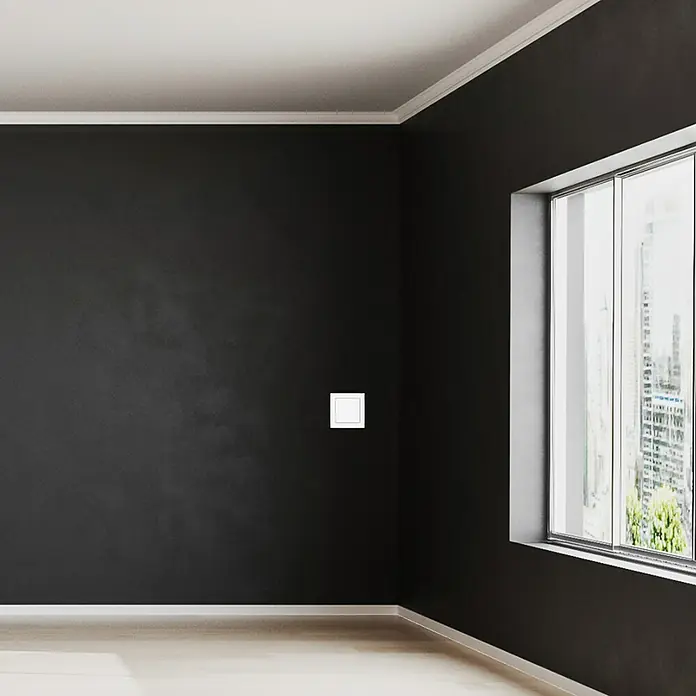Luceco Oxford Conmutador - Blanco, Mate, Montaje en la pared, 10 A, 5 ud. - Un interruptor de luz cuadrado y empotrado en una pared oscura proporciona iluminación minimalista en una habitación moderna.