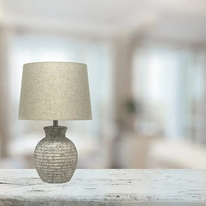 Lámpara de sobremesa de cerámica - 40 W, L x An x Al: 36 x 36 x 56 cm, Beige arena, E27 - Elegante lámpara de mesa con una base texturizada y una pantalla sencilla sobre una mesa blanca con un fondo difuminado.