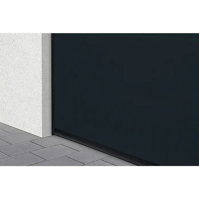 Solid Elements Garagentor Solid Pro Iso - 2.500 x 2.125 mm, Außen: Anthrazitgrau, Innen: Grauweiß - Nahaufnahme einer modernen, anthrazitfarbenen Garagentor-Sektion, die mit einer weißen Wand und grauem Pflaster harmoniert.