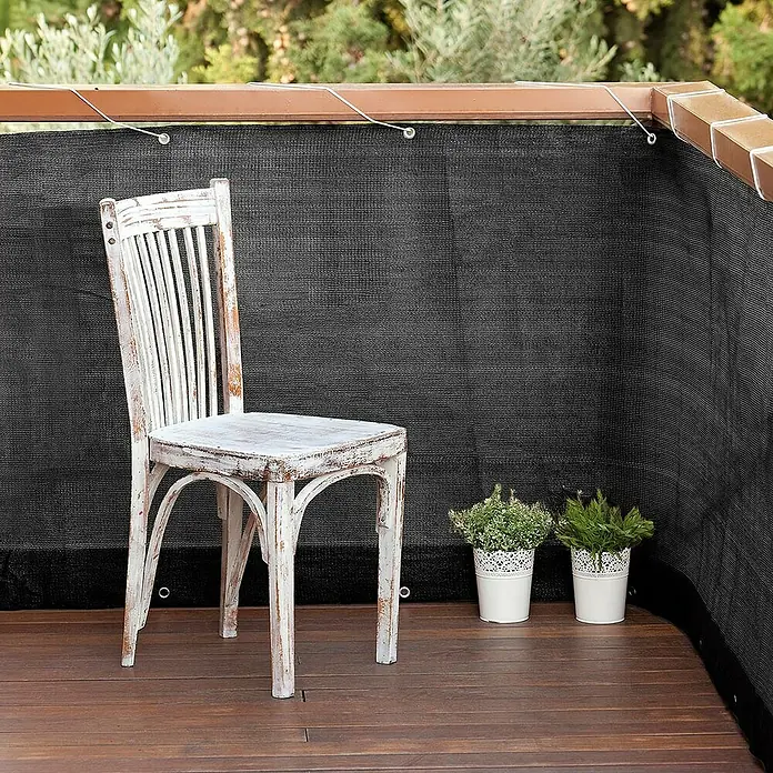 Nortene Balkonsichtschutz - 300 x 90 cm - Ein weißer Stuhl und zwei Topfpflanzen stehen auf einer Holzterrasse mit einem blickdichten Sichtschutz.