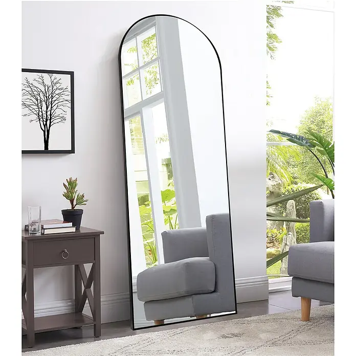 Rahmenspiegel Malva - 50 x 150 cm, Schwarz, Aluminium - Elegantes Ganzkörperspiegel mit schwarzem Rahmen. Der Spiegel reflektiert einen Sessel und einen hellen Raum.