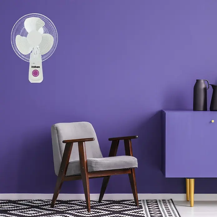 Ventilador de pared Fresco - Blanco, 40 cm - Ventilador Ithhon de pared en una habitación moderna con paredes moradas, un sillón y un mueble.