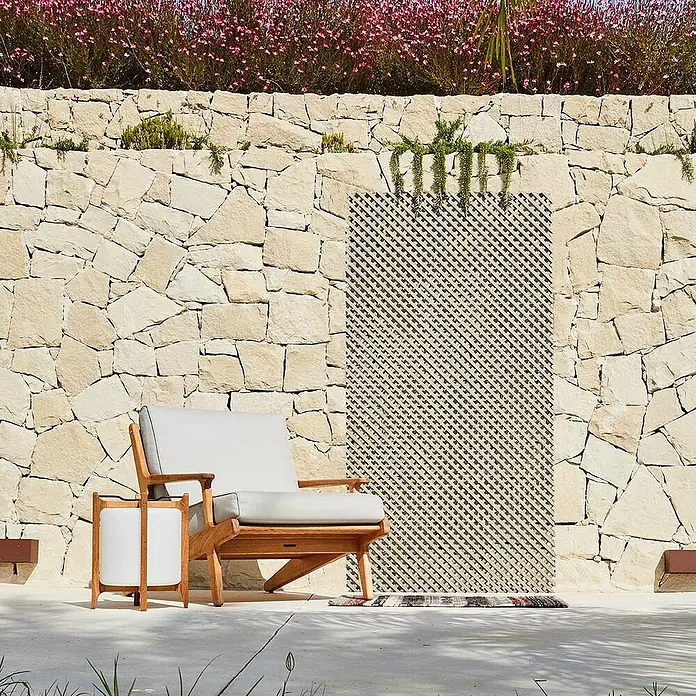 Nortene Rankgitter - 60 x 120 cm, Elfenbein, Kunststoff - Gartenmöbel-Set mit einem Holzstuhl und Beistelltisch auf einer Terrasse mit Steinmauer und Blumen im Hintergrund.