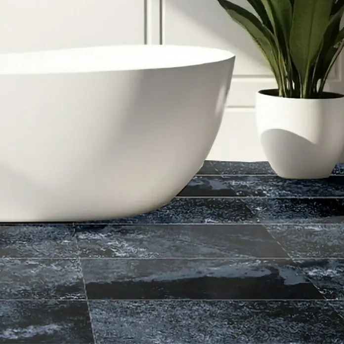 Feinsteinzeugfliese Oceanic - 29,7 x 59,7 cm, Blau, Glänzend - Elegante freistehende Badewanne auf dunkelblauem Bodenbelag und grüner Topfpflanze im Badezimmer mit klaren Linien.