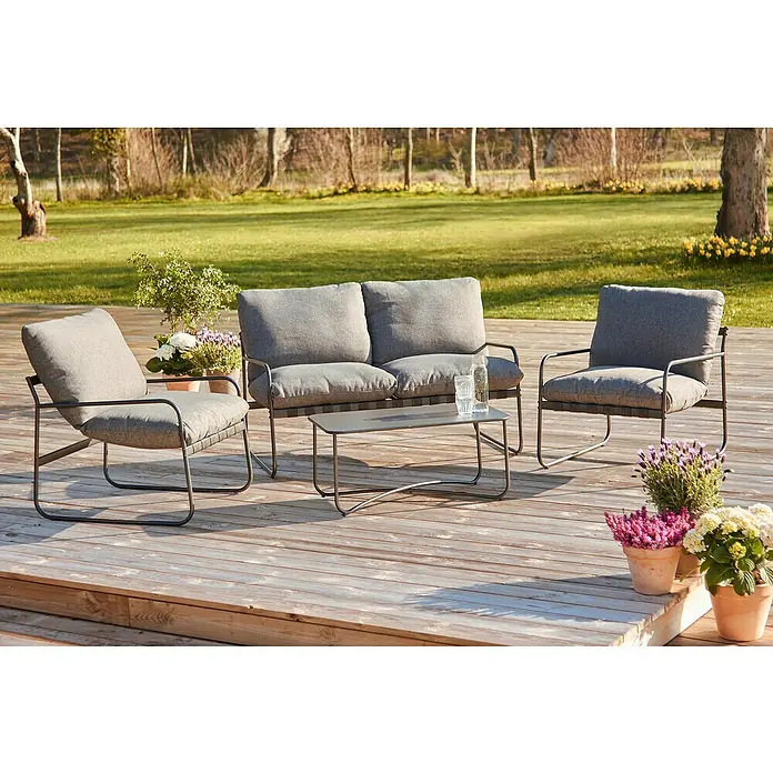 Conjunto de muebles Theodor - 4 pzs., Acero/Poliéster, Antracita - Un conjunto de salón de exterior gris con dos sillones, un sofá y una mesa de centro colocado en un patio de madera.
