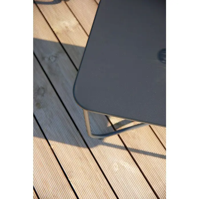 Conjunto de muebles Theodor - 4 pzs., Acero/Poliéster, Antracita - Detalle de una esquina de una mesa gris moderna sobre una terraza de madera, destacando su textura y diseño minimalista.