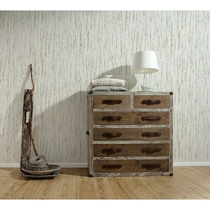 A.S. Création Vliestapete Putzstruktur - Weiß/Beige, Uni, L x B: 10,05 x 0,53 m - Diese Aufnahme zeigt eine rustikale Kommode aus Holz mit mehreren Schubladen, ideal für Stauraum und Dekoration in Ihrem Zuhause.