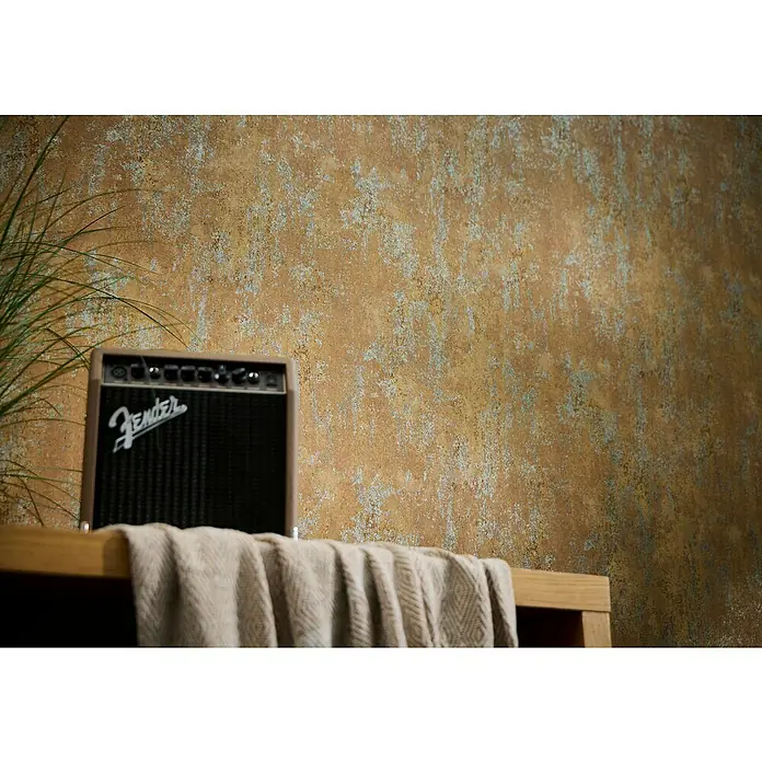 A.S. Création Metropolitan Stories Hot Spots Vliestapete Putzstruktur - Braun-Orange-Grau, Steinoptik, 10,05 x 0,53 m - Nahaufnahme eines Fender-Verstärkers auf einem Tisch mit einem Tuch davor, vor einer strukturierten Wand.
