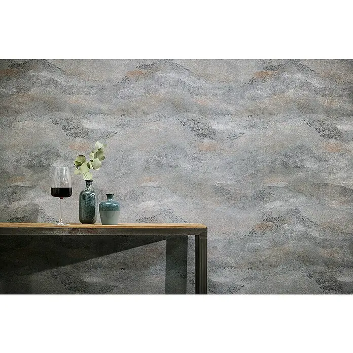 A.S. Création Metropolitan Stories Hot Spots Vliestapete Wellengrafik - Grau-Braun-Metallic, Wellen, 10,05 x 0,53 m - Wein und Vasen auf einem Holztisch vor einer strukturierten Wand.