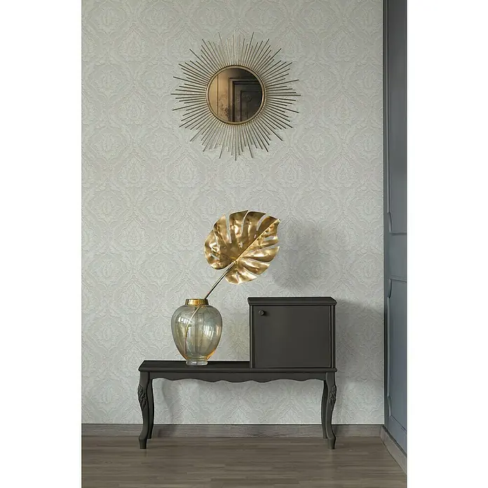 A.S. Création Vliestapete Ornament Barock - Weiß Glitzer, L x B: 10,05 x 0,53 m - Einrichtungsgegenstände auf einem dunklen Tisch: Goldfarbenes Blatt in einer Vase, Spiegel und ein kleiner Schrank.