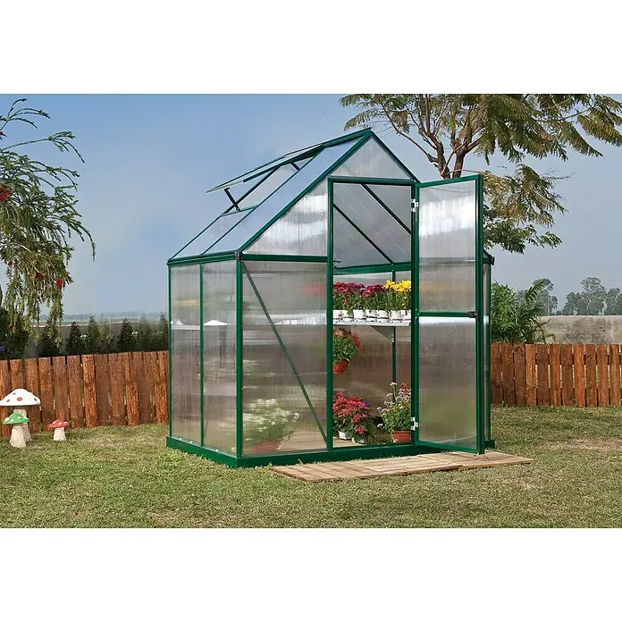 Palram – Canopia Gewächshaus Mythos 6x4 - Außenmaß inkl. Dachüberstand (B x T): 185 x 126 cm, 4 mm, Grün - Bild eines Gewächshauses mit grünen Rahmen, das im Garten steht und mit Blumen bepflanzt ist, die auf Regalen stehen.