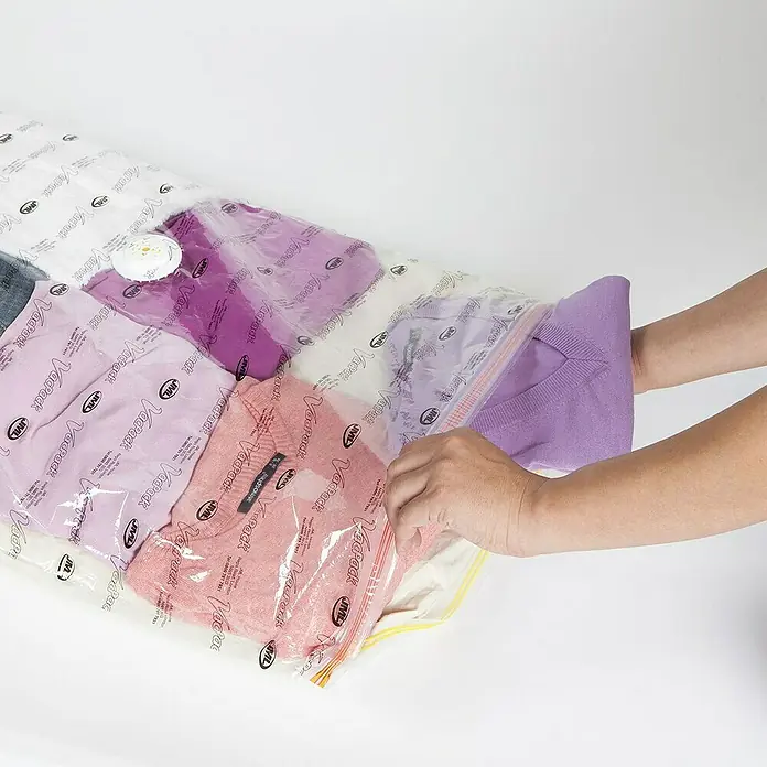 Bolsa de vacío VacPack GO! - L x An: 85 x 55 cm, 2 ud. - Las manos están cerrando una bolsa de vacío llena de ropa, ideal para ahorrar espacio.