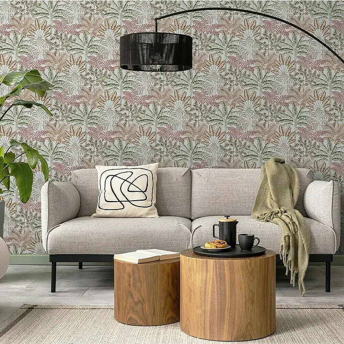 Papel pintado Botánico Palmeras - Beige, Floral, 10 x 0,53 m - Escena de salón con sofá gris, cojín decorativo, mesas auxiliares de madera, alfombra y lámpara de pie.