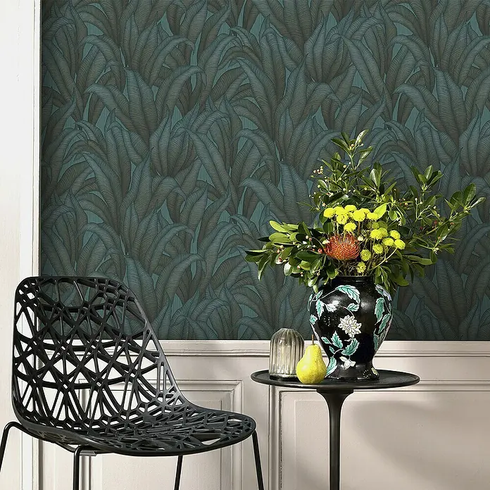 Papel pintado Hojas Botánico - Verde, Floral, 10 x 0,53 m - Interior elegante con papel pintado de hojas, silla moderna y jarrón de flores en mesa auxiliar.