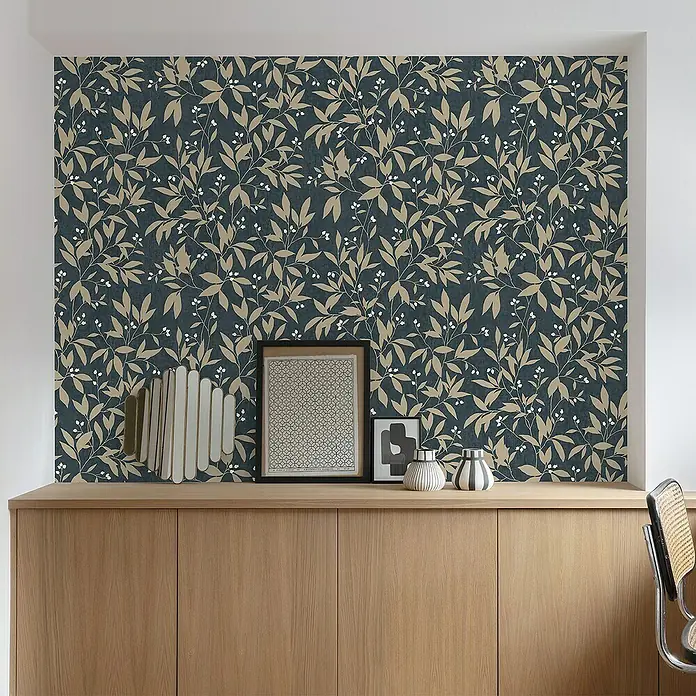 Papel pintado Vegetal Hojas - Azul/Beige, Floral, 10 x 0,53 m - Primer plano de una habitación elegante con aparador, elementos decorativos y papel tapiz con motivos de hojas en tonos beige y azul.