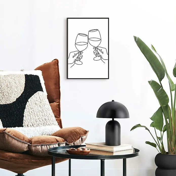 Reinders Bild Slim Frame - Wine Lines, B x H: 20 x 30 cm - Ein gerahmtes, minimalistisches Wandbild mit zwei anstoßenden Weingläsern hängt über einem Tisch mit Lampe.