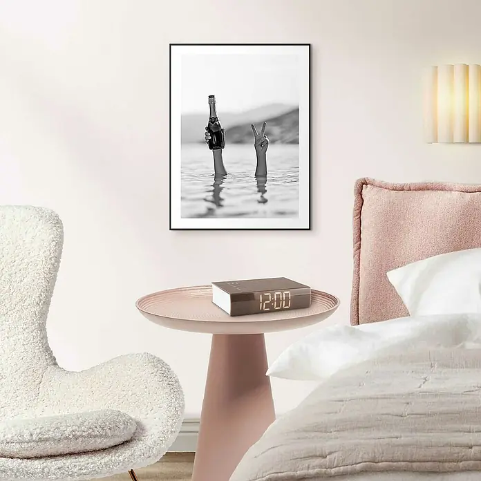 Reinders Bild Slim Frame - Sea Cheers, B x H: 30 x 40 cm - Schwarzes gerahmtes Bild mit Händen, die eine Flasche und ein Friedenszeichen im Wasser halten, hängt an einer weißen Wand.