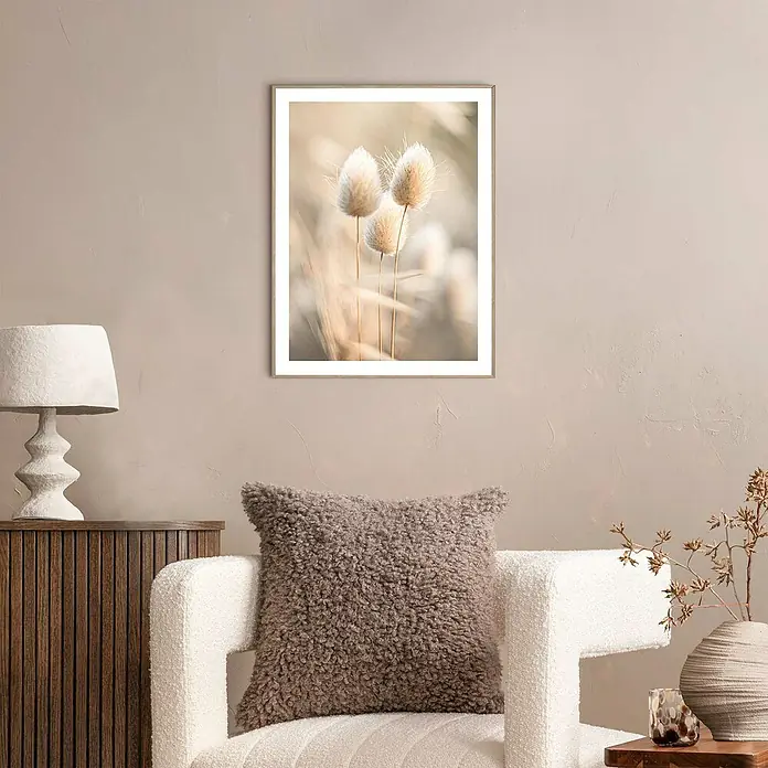 Reinders Bild Slim Frame - Ambient Plumes, B x H: 30 x 40 cm - Ein stilvolles Interieur mit einem gerahmten Kunstwerk von zarten Gräsern über einem Sessel mit Kissen und einer Lampe auf einem Sideboard.