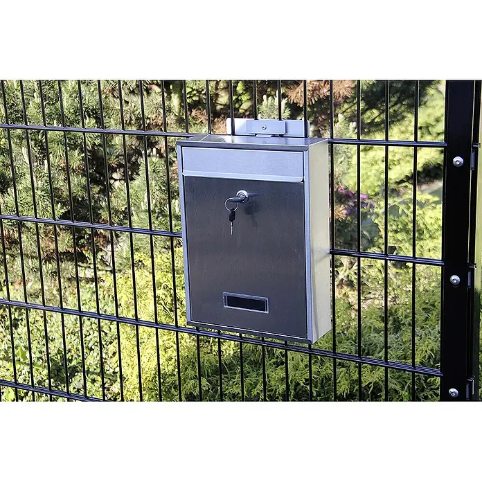 WMT Eindrehhalterung für Briefkasten - Dunkelgrün - Ein silberfarbener Briefkasten mit Schlüssel hängt an einem schwarzen Zaun. Er hat eine Einwurföffnung und ein Schlüsselloch.