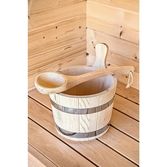 Tuindeco Aufguss-Set - Holz - Eine traditionelle Saunaeimer und eine Schöpfkelle aus hellem Holz mit Metallreifen stehen auf einem Holzfußboden vor einer Holzwand.