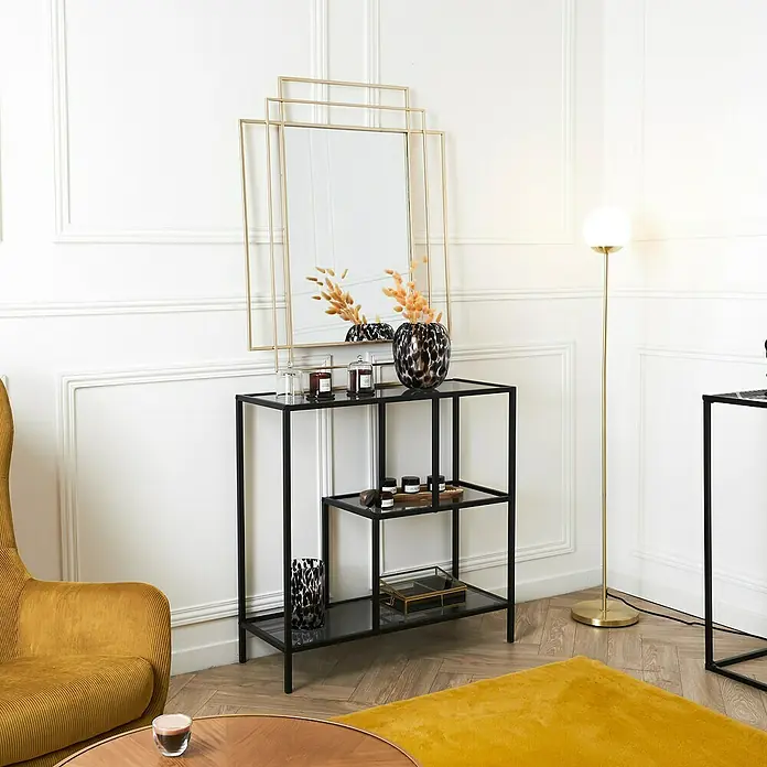 Home Deco Factory Edison Estantería metálica - L x An x Al: 30 x 80 x 79,5 cm, Metal/Vidrio templado, Negro - Interior elegante con una consola de metal negro y vidrio, decorada con velas y un jarrón, bajo un espejo dorado.