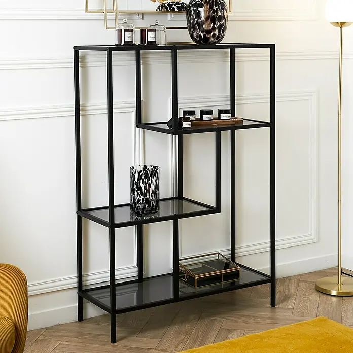 Home Deco Factory Edison Estantería metálica - L x An x Al: 30 x 80 x 113 cm, Metal/Vidrio templado, Negro - Una moderna estantería negra con estantes de vidrio, que muestra elementos decorativos. Está contra una pared blanca.