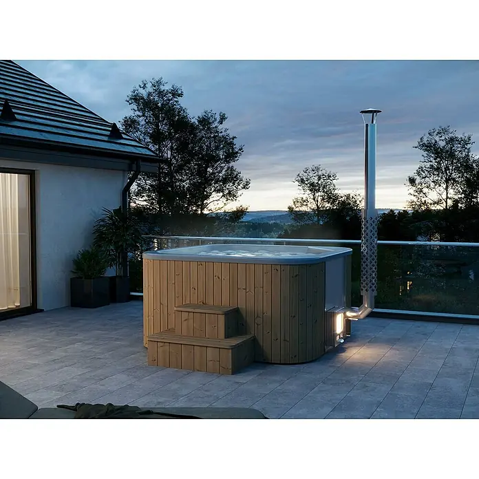 Tuindeco Hot Tub - 205 cm, Kiefer, Natur, Max. Personenzahl: 6 Stk. - Außenaufnahme eines holzbefeuerten Badezubers mit Treppe und Edelstahlkamin auf einer Terrasse.