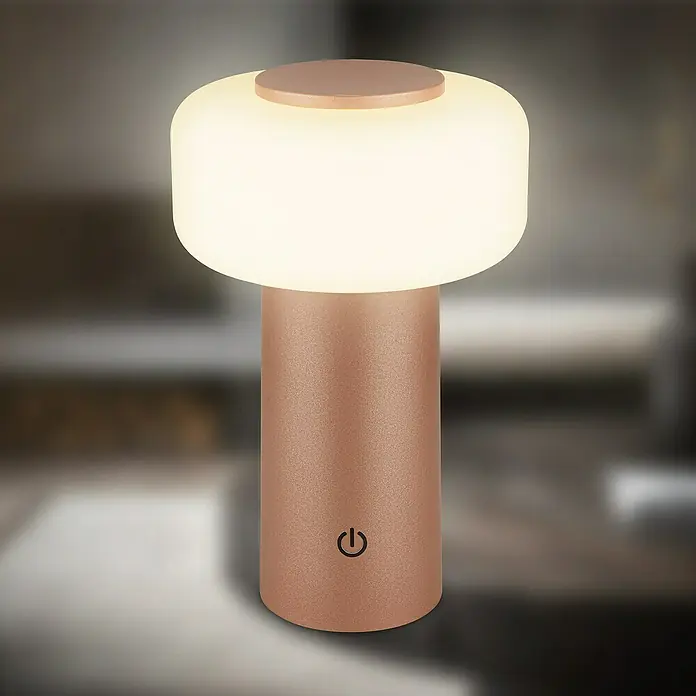 Brilo Akku-Tischleuchte Juna - Ø x H: 13 x 20,5 cm, Coffee, Warmweiß, 1,8 W, IP44 - Nahaufnahme einer modernen, runden Tischleuchte in Roségold mit einem sanften, warmen Lichtschein, ideal für eine gemütliche Atmosphäre.