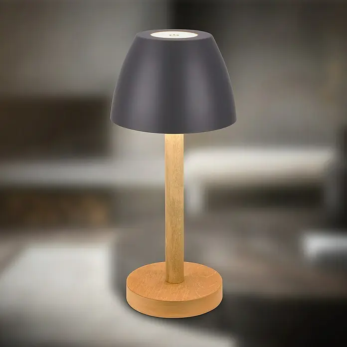 Brilo Akku-Tischleuchte Serina Wood - Ø x H: 13,5 x 20 cm, Anthrazit, Warmweiß, 2,5 W, IP44 - Elegante Tischleuchte mit grauem Schirm und Holzfuß, die ein warmes Licht ausstrahlt und eine gemütliche Atmosphäre schafft.