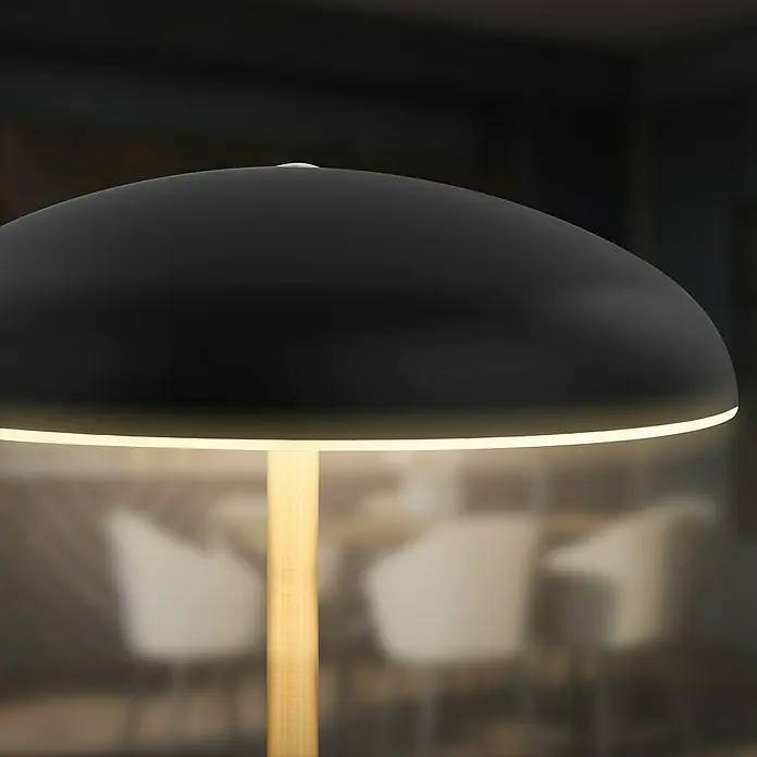 Brilo Akku-Tischleuchte Caxa - Ø x H: 19,5 x 30,5 cm, Schwarz, Warmweiß, 2,8 W, IP44 - Nahaufnahme einer eleganten schwarzen Tischleuchte mit Holzfuß, die ein warmes, einladendes Licht ausstrahlt.\n