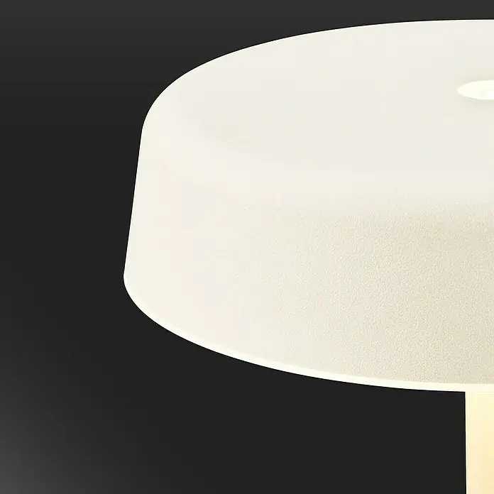 Brilo Akku-Tischleuchte Pala - Ø x H: 13 x 36,5 cm, Altweiß, Warmweiß, 2,6 W, IP44 - Nahaufnahme einer eleganten, runden Tischleuchte mit sanftem Lichtschein und modernem Design vor dunklem Hintergrund.