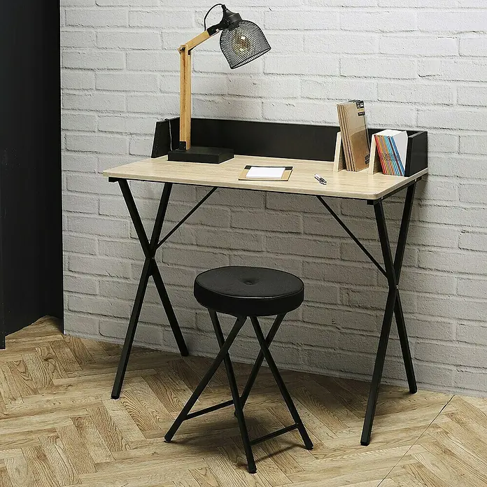 Home Deco Factory Mesa de escritorio - L x An x Al: 50 x 90 x 85 cm, Negro/Madera - Un escritorio moderno con lámpara y taburete frente a una pared de ladrillos, ofreciendo un espacio de trabajo elegante para el hogar.