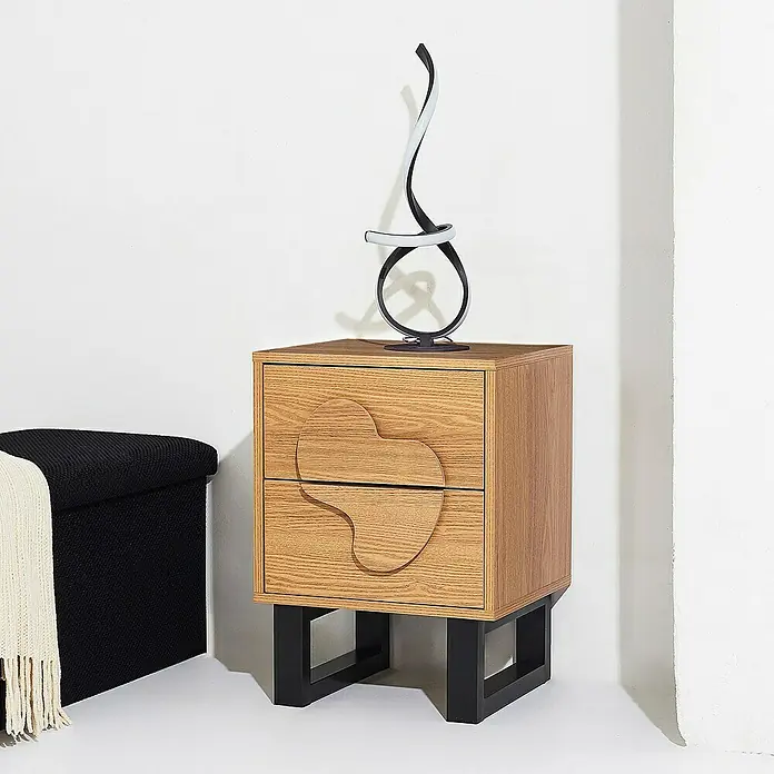 Home Deco Factory Calypso Cómoda con mesitas - 3 pzs., Marrón/Negro, Relieves curvos - Elegante mesita de noche de madera con dos cajones y una lámpara moderna encima, junto a un taburete negro.
