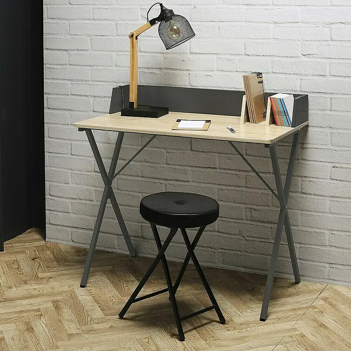 Home Deco Factory Mesa de escritorio - L x An x Al: 50 x 90 x 85 cm, Gris/Madera - Un escritorio elegante con un brazo de lámpara de madera y un taburete negro sobre un suelo de madera frente a una pared de ladrillo.