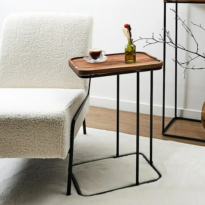 Home Deco Factory Mesa auxiliar Acacia - L x An: 30 x 40 cm, Marrón/Negro - Primer plano de una mesa auxiliar moderna con tablero de madera y estructura metálica negra junto a un sillón blanco, decorada con taza y jarrón.