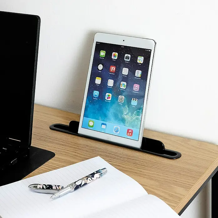 Home Deco Factory Mesa de escritorio Link - L x An x Al: 50 x 90 x 76 cm, Marrón/Negro - Un iPad Mini está en un soporte negro sobre una mesa de madera, al lado hay un bloc de notas y un bolígrafo.