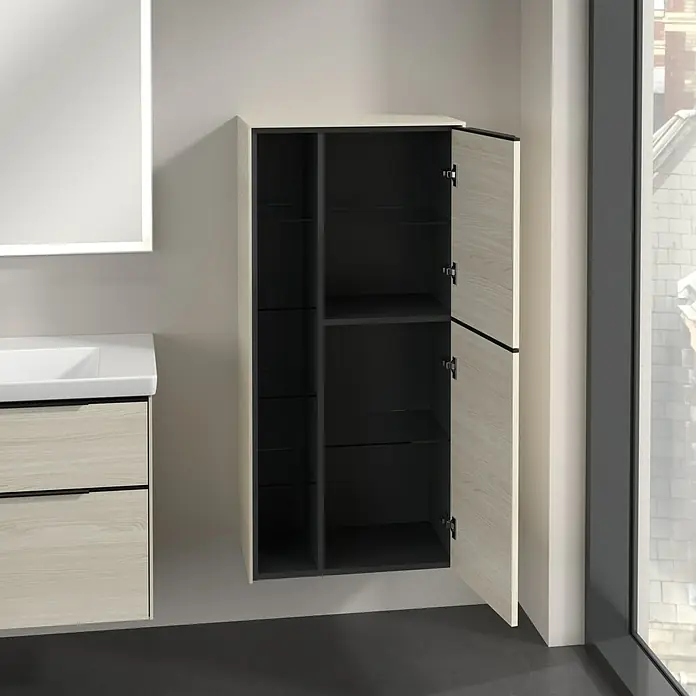 Villeroy & Boch Subway 3.0 Seitenschrank - B x T x H: 57,4 x 36,2 x 120 cm, White Oak, DIN Anschlag: Rechts, Farbe Griff: Volcano Black - Ein offener Badezimmerschrank in hellen Holztönen mit dunklen Innenfächern. Der Schrank hängt an einer hellen Wand neben einem Fenster.