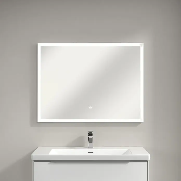 Villeroy & Boch Subway 3.0 Lichtspiegel - 100 x 75 cm, White Matt - Bild eines rechteckigen Spiegels mit LED-Beleuchtung über einem weißen Waschbecken mit Armatur vor einer grauen Wand.