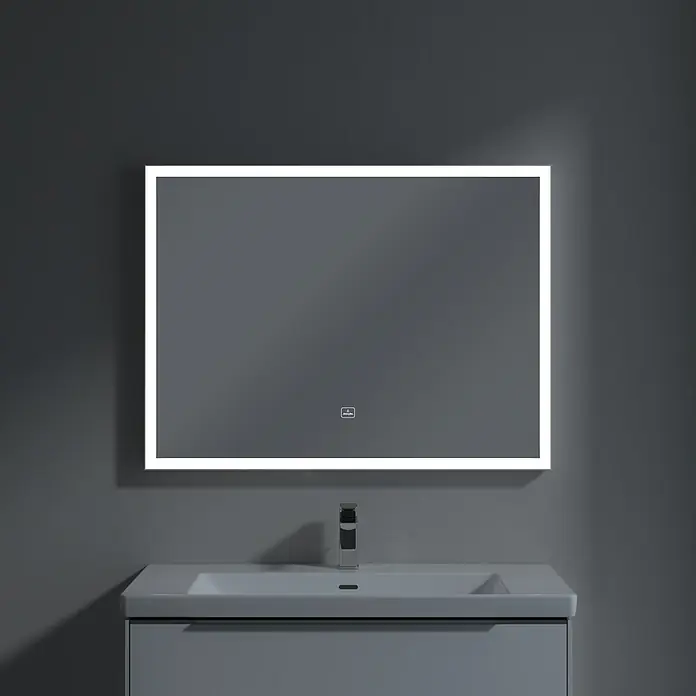 Villeroy & Boch Subway 3.0 Lichtspiegel - 100 x 75 cm, White Matt - Ein rechteckiger LED-beleuchteter Spiegel hängt über einem modernen Waschbecken mit grauer Wand im Hintergrund.